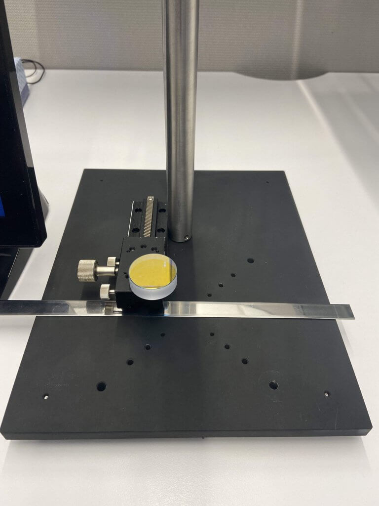 Figure 1: Suruga Seiki Optical Mirror compared to stainless steel strip. The sensor is tuned to the mirror.